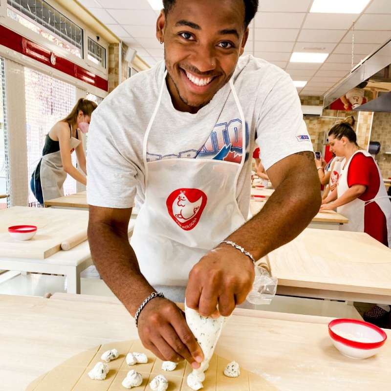 A student piping filling onto a pastry.