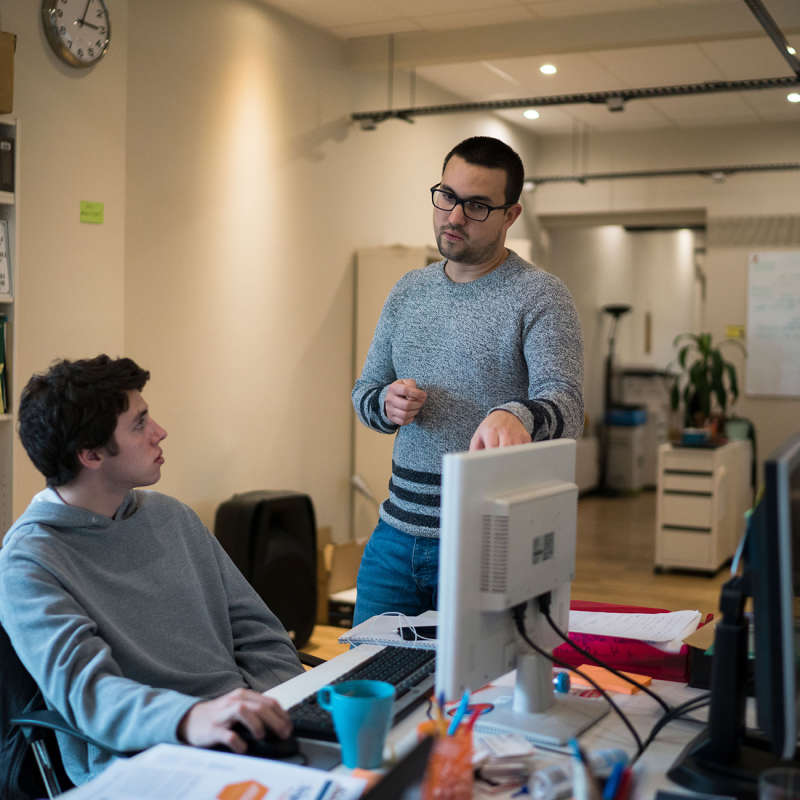 A supervisor gives a student directions at his internship.