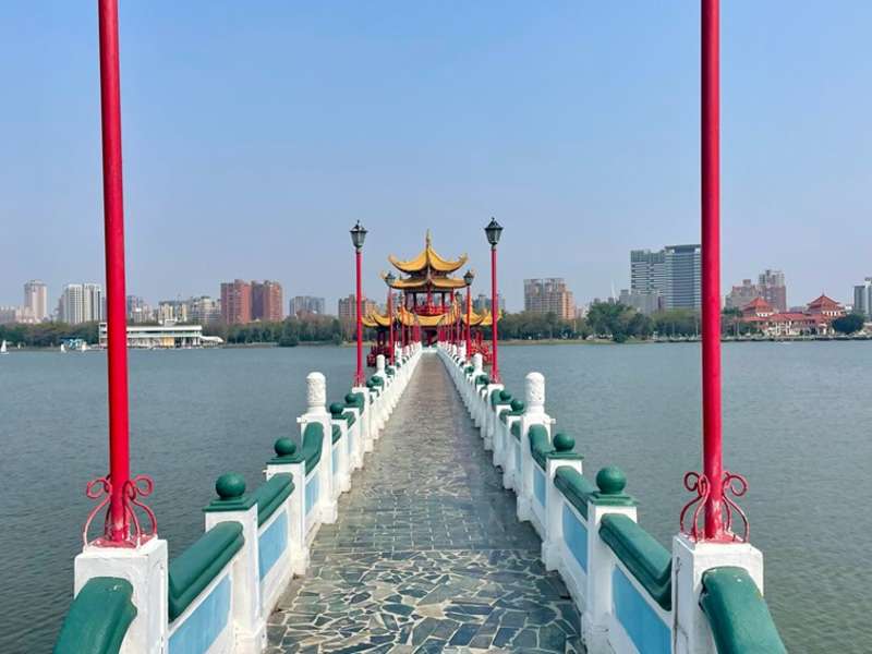 A temple on a lake with a city skyline behind