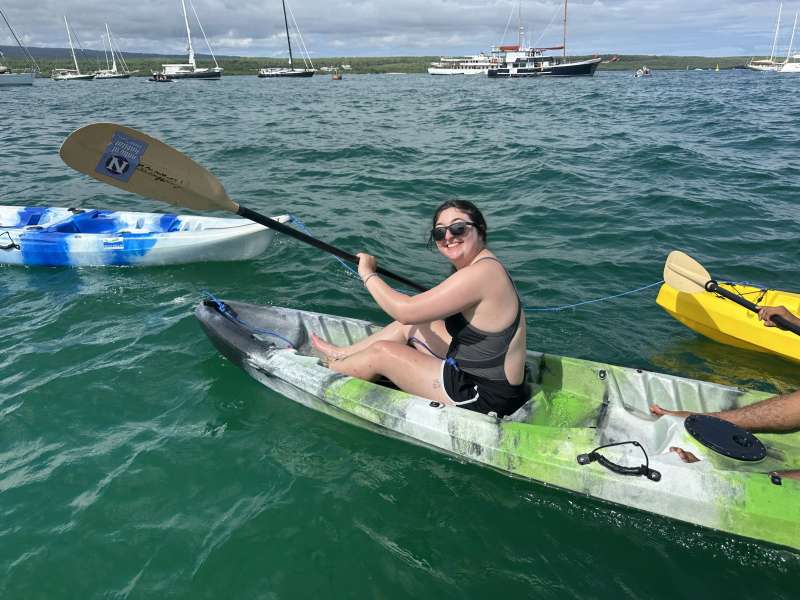 A woman kayaks in a bay