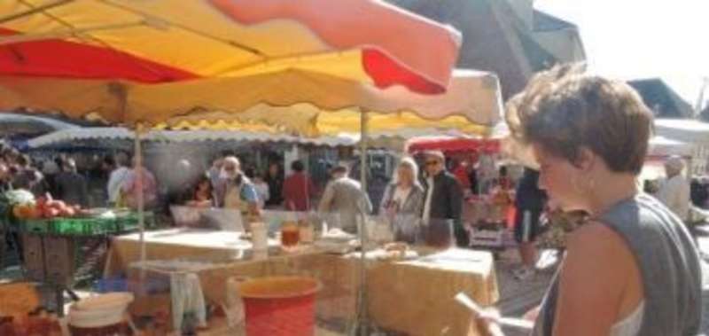 A woman stands in front of a market stall