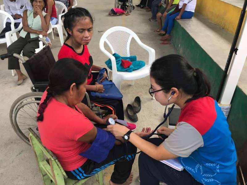 A woman takes blood pressure of patient.