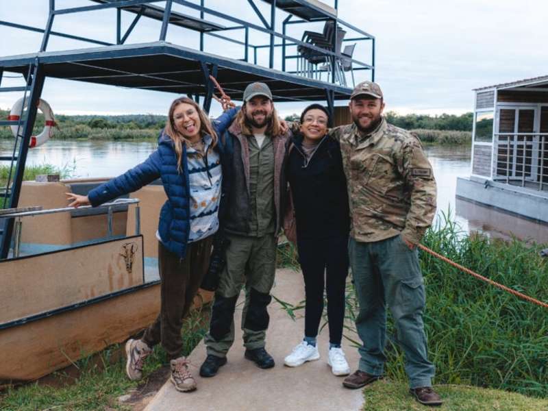 ACE volunteer group posing beside a boat at the water