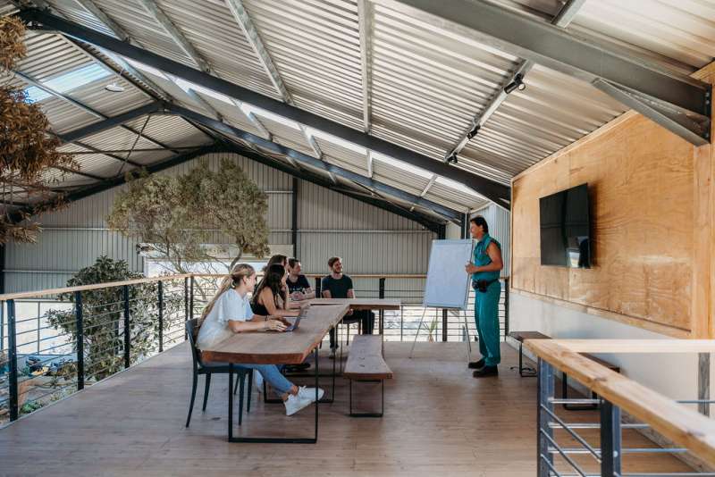 An instructor gives a presentation to people at a table.
