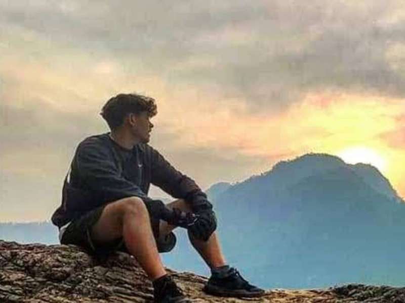 An intern watches the sun set over a mountain