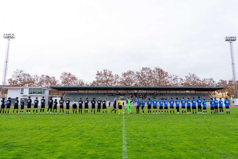 back of soccer players lined up on a soccer field