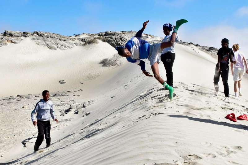 Boarders running down sand dunes at Diaz Point