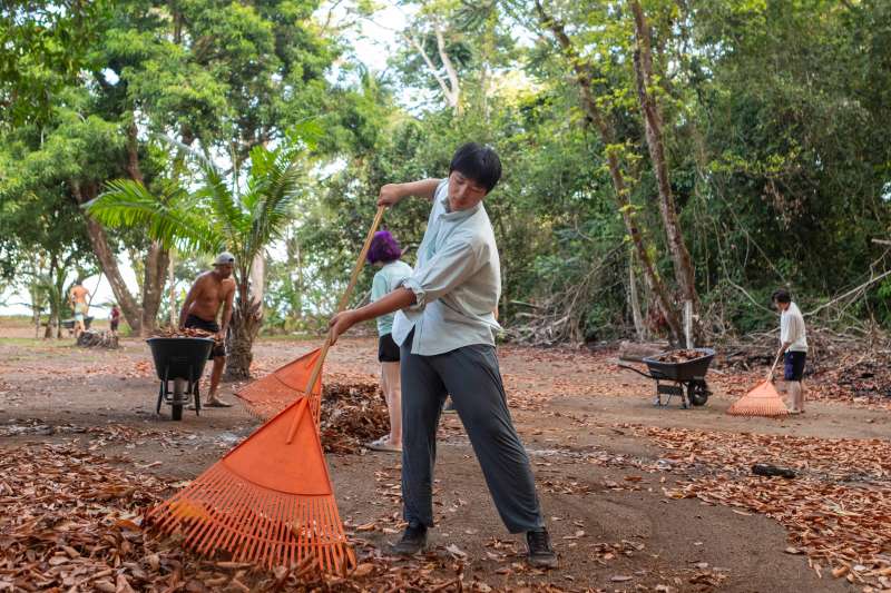 Boy rakes leaves with trail maintenance crews. 