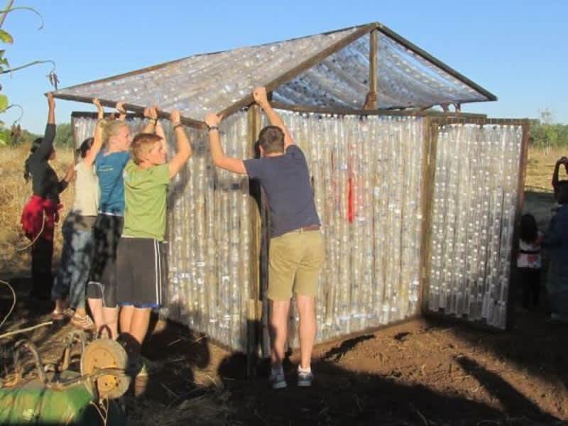 building volunteers holding a roof together