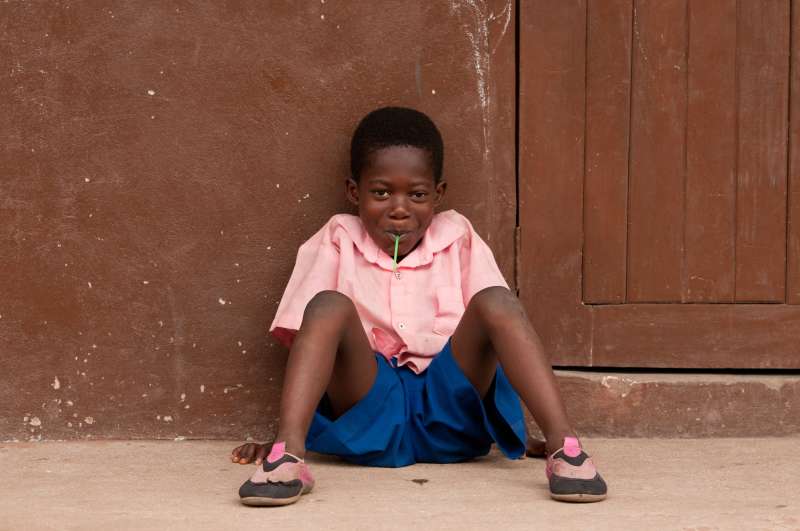 Child in pink chewing a stem