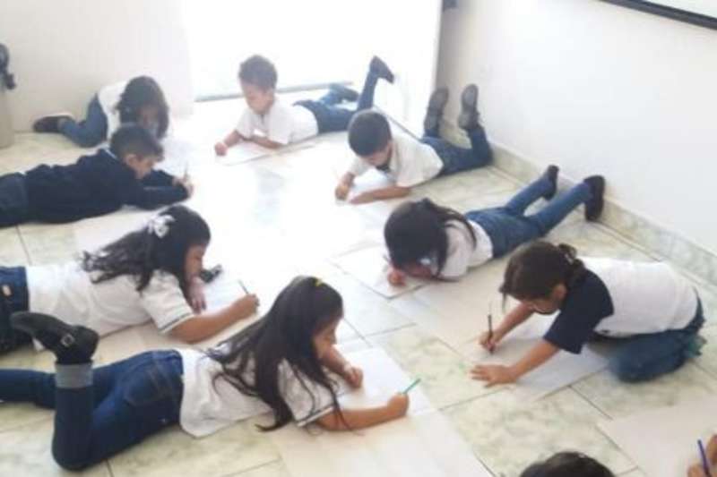 Children writing on the floor