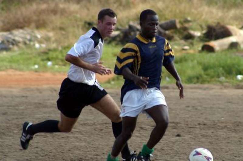 Volunteer playing football with local