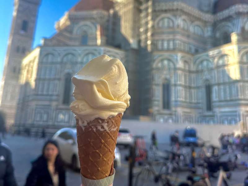 Cone of gelato with a cathedral in teh background