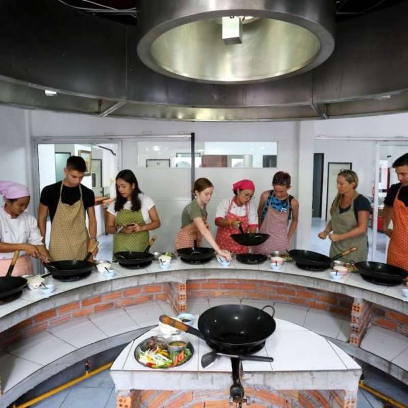Teens learning how to cook Thai meals in a private cooking class.