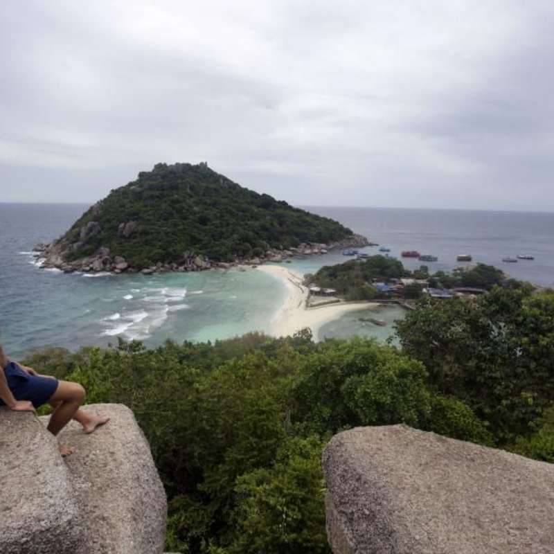 Teen looking out at a coastal landscape in Thailand on a summer travel trip.