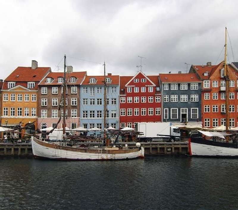 A photo of Danish architecture and boats near a port.