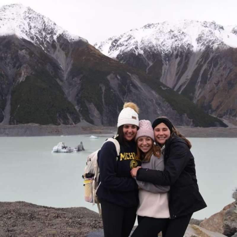 three teen girls hugging on a glacier tour in new zealand
