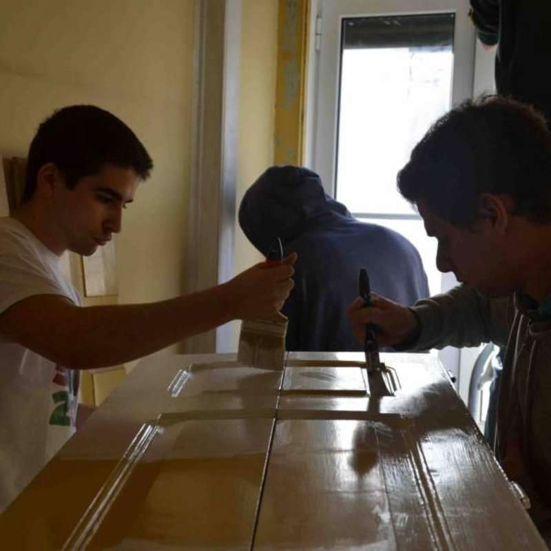 young volunteers painting a door