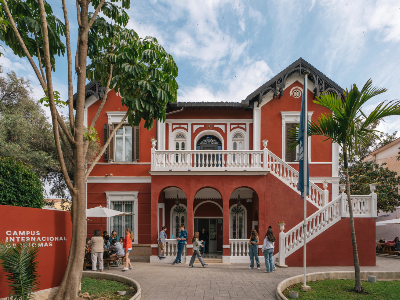 EF Málaga campus building in Spain with red walls, white balconies, and students gathered outside, blending historic architecture with a lively study abroad atmosphere.