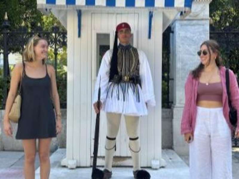 Female students posing with guard in Athens, Greece