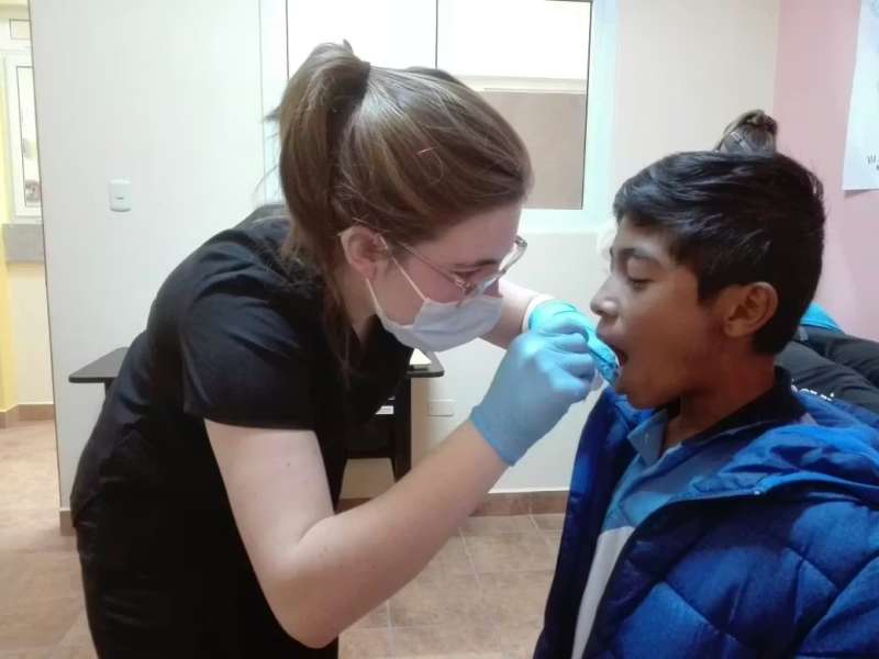 Female Volunteer Checking a Childs Mouth