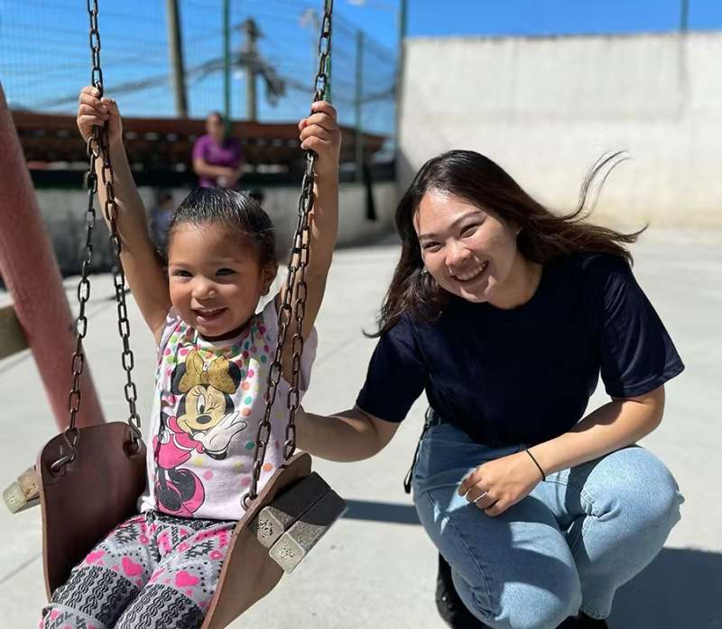 Female Volunteer pushing a Child on a Swing in Costa Rica