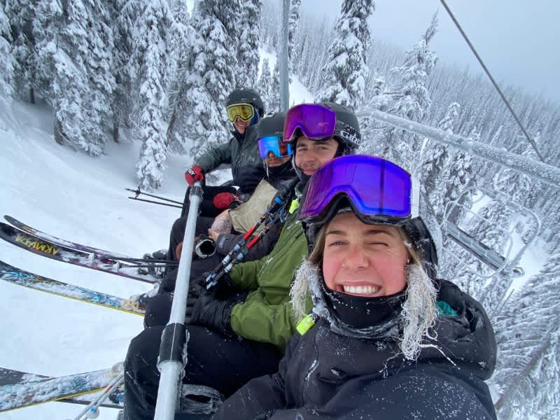 Four people on a ski lift in ski gear in the winter
