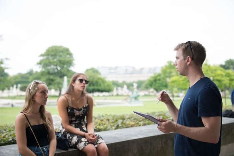 French language instructor talking to two students outdoors