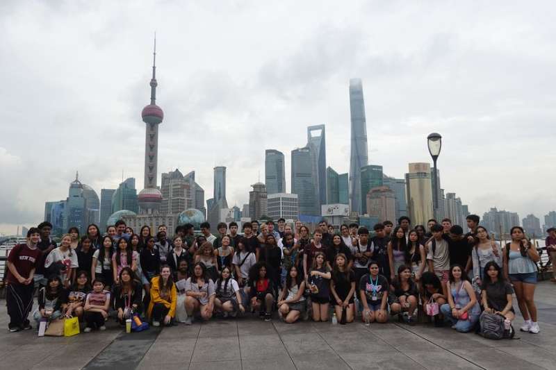 Gap students posing in Shanghai with skyline behind them