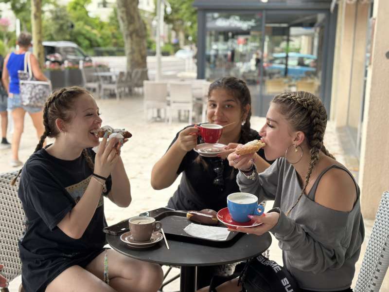Girls eating croissants and drinking espresso in France 