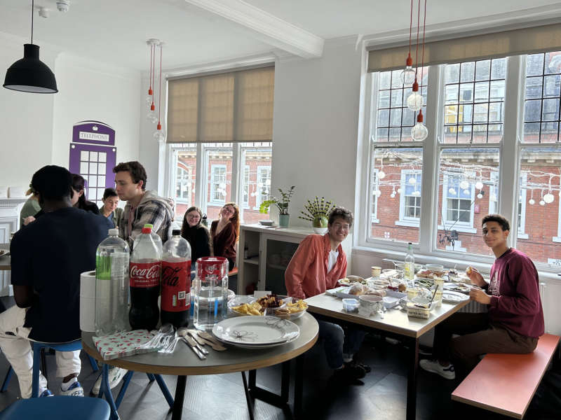 Group eating around tables and talking.