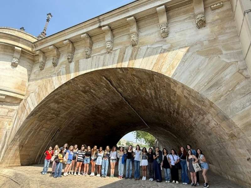 Group of participants posing under bridge in Paris