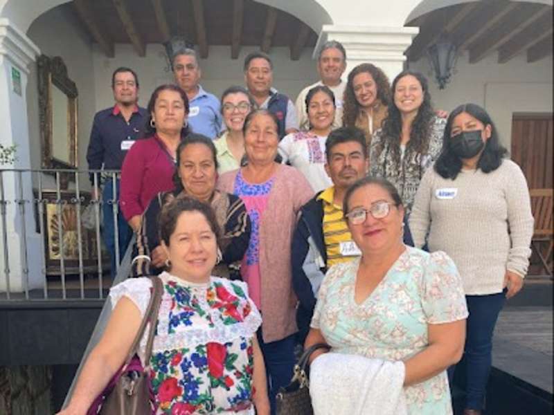 Group of people smiling and standing together in a collaborative setting, representing a team or internship group.