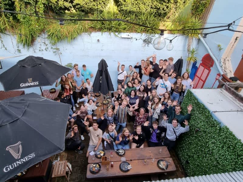 Group of people smiling and waving for a photo