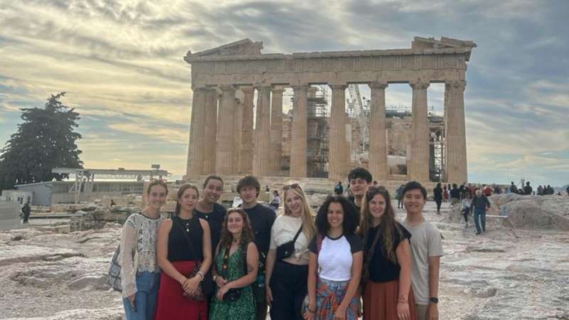 group of students with The Acropolis, Athens background