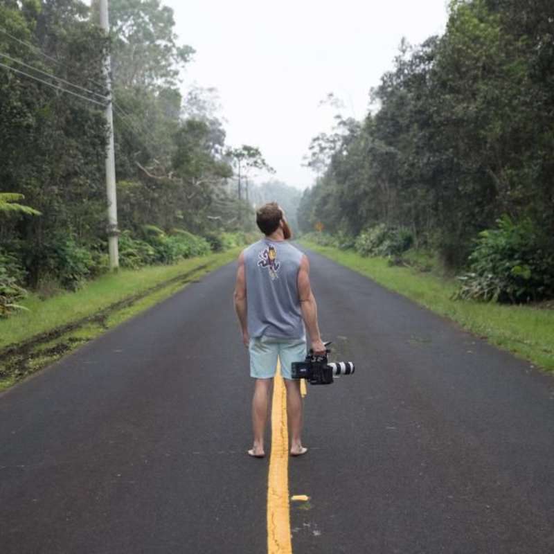 man on the middle of the road surrounded with trees
