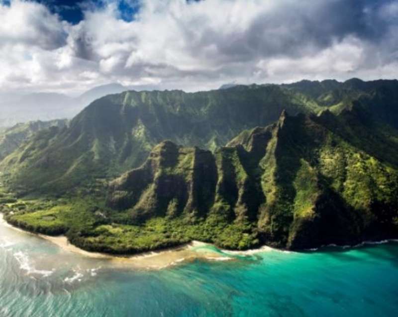 aerial view of hawaiian coast with mountains and forest