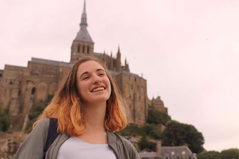 High school girl smiling in front of castle in Rennes