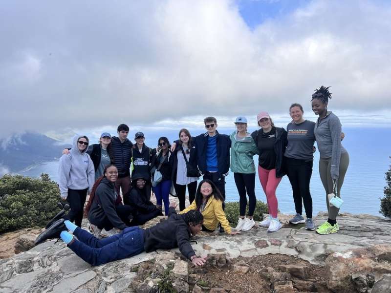High school students on cliff near the water in Cape Town