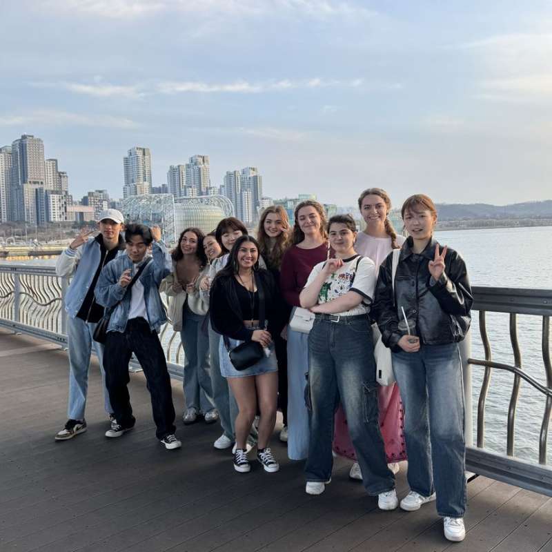 High school students posing with Seoul skyline behind them
