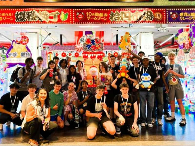 High schoolers posing in front of arcade in Kyoto