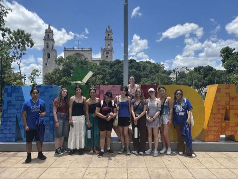 High schoolers posing in front of Merida sign in Mexico on study abroad program