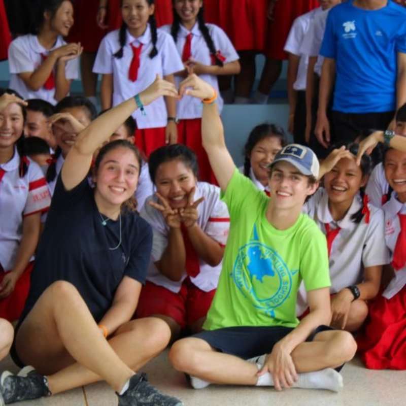 teens smiling with school children Thailand