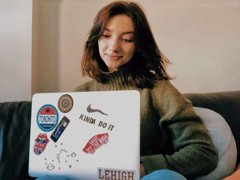 Intern working on laptop on a couch