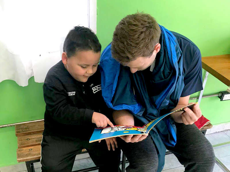 IVHQ Volunteer reading a child a picture book 