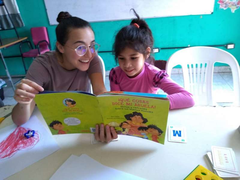IVHQ Volunteer reading a child a picture book 