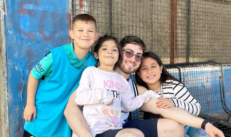 IVHQ Volunteer taking a photo with three children 