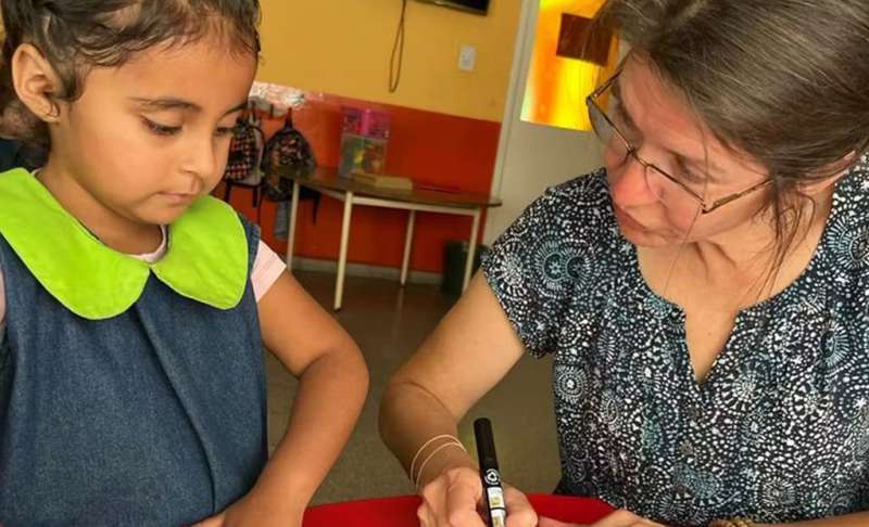 IVHQ Volunteer teaching a young child English in Argentina.
