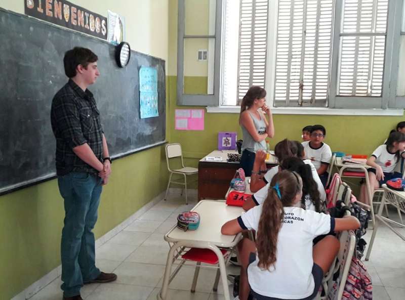 IVHQ Volunteers standing in front of a blackboard teaching students.