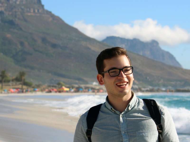 Male student smiling in front of table mountain